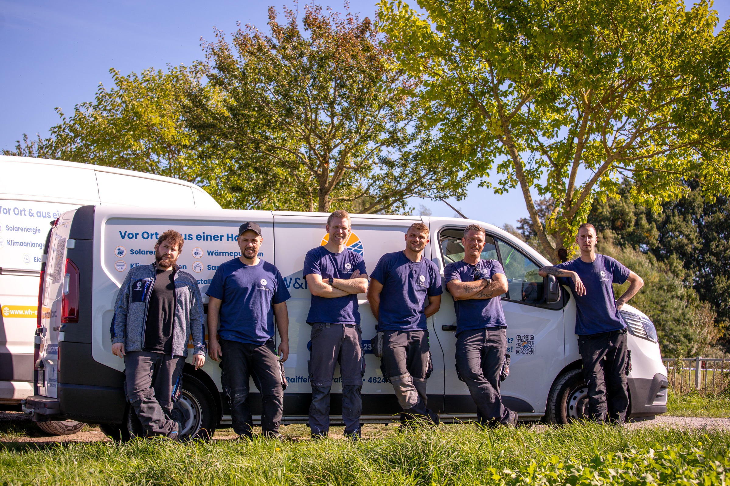 Das Team von W&H Solar vor den Firmenfahrzeugen